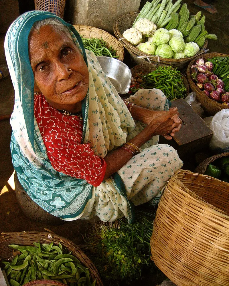 A vegetable seller with fresh produce at a local market