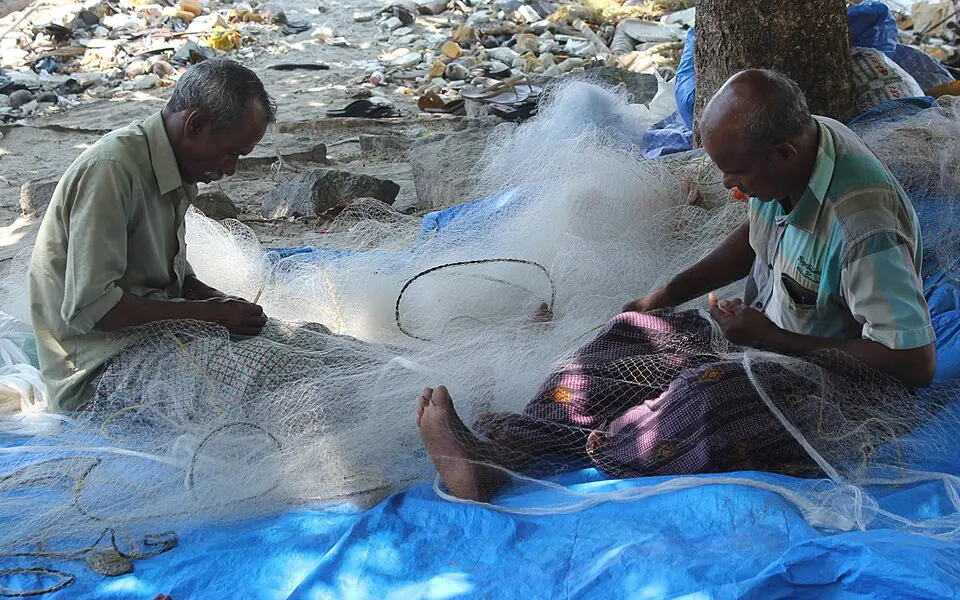 Fishermen mending their nets together